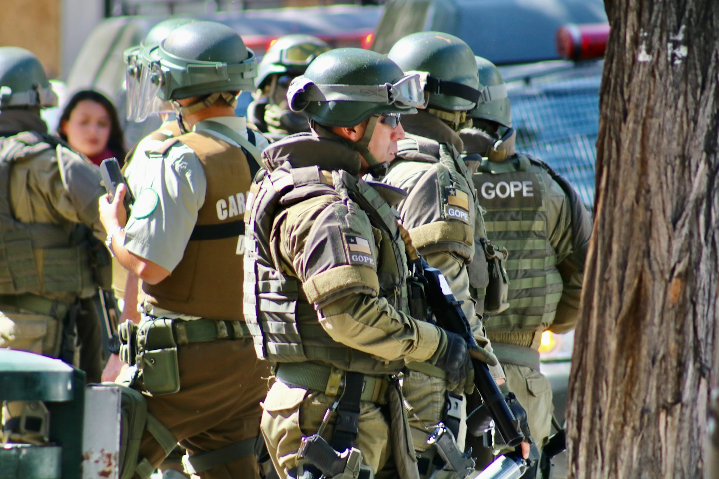 Chilean GOPE officers in tactical gear stand ready outdoors.